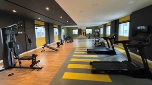 A gym with treadmills, weight machines, and a wooden floor. - Apto Allianz Metrô Barra Funda (Várzea da Barra Funda São Paulo)
