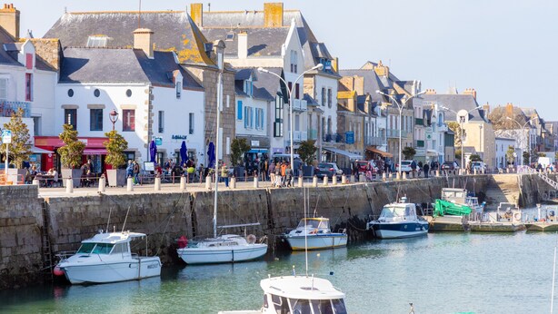 A harbor with boats docked, a stone wall, and buildings with balconies. - Apartment 'Appartement Face Mer Et Piscine' with Sea View, Shared Pool and Wi-Fi (Le Croisic)