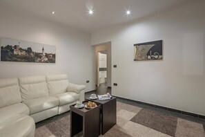 A modern living room with a sofa, coffee table, and artwork on the walls.