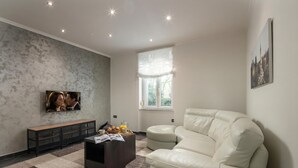 A modern living room with a sectional sofa, a coffee table, a bench, and a television. - Quiet City Apartment Dexa, Rijeka, Croatia (Rijeka)