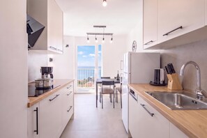 Une cuisine moderne avec vue sur la mer, un coin repas et une grande fenêtre.