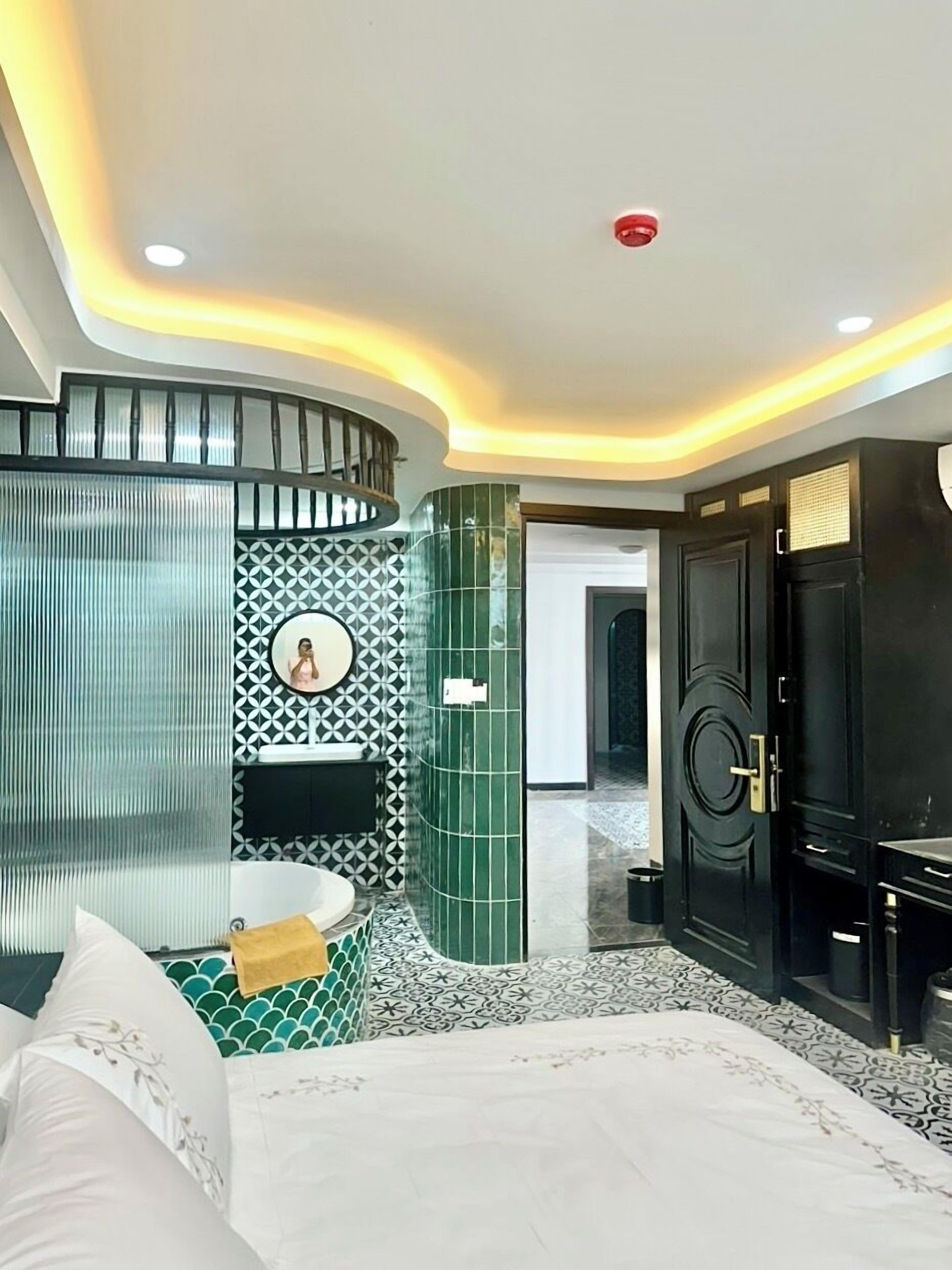 A modern bedroom with a curved ceiling, a built-in fireplace, a large bed, and a black wardrobe.