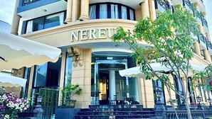 Ein mehrstöckiges Hotel mit klassizistischer Fassade, das sich durch schmiedeeiserne Balkone und einen prunkvollen Eingang auszeichnet.