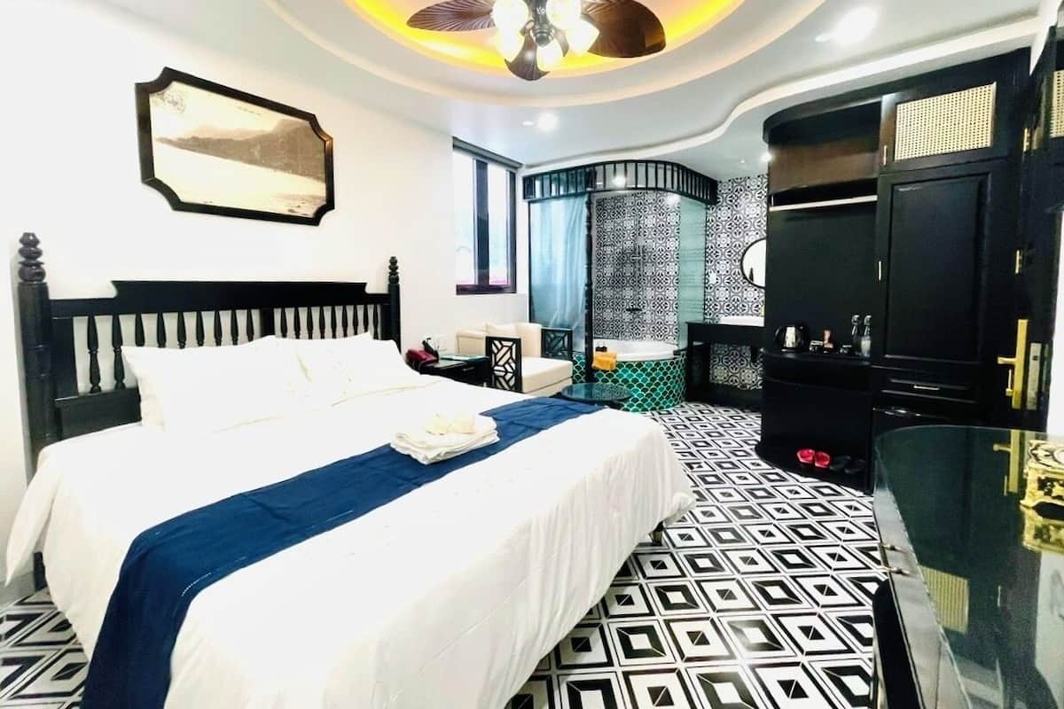 Ein Hotelzimmer mit Bett, Kleiderschrank, Bad und Deckenventilator.