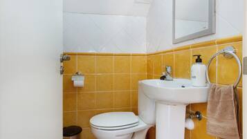 A bathroom with a toilet, sink, and towel rack.