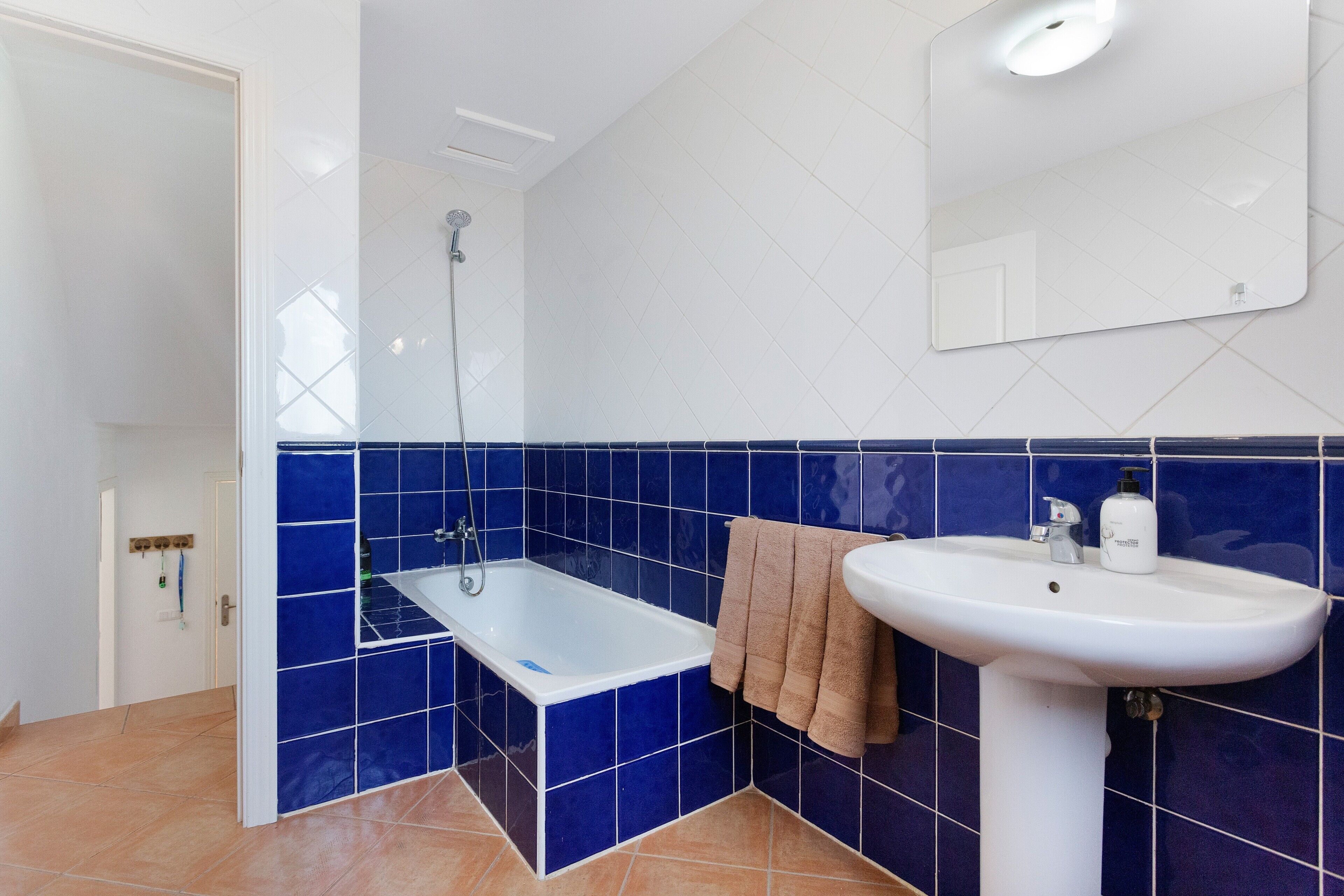 Un baño con bañera, lavamanos y espejo.