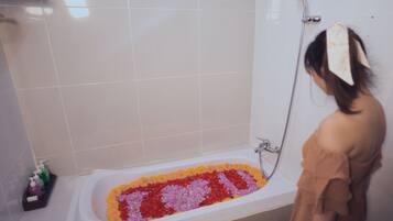 A bathtub filled with colorful flower petals.