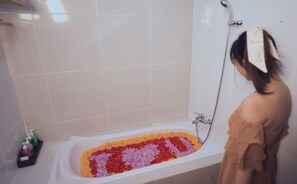 Una bañera llena de pétalos de flores de colores.