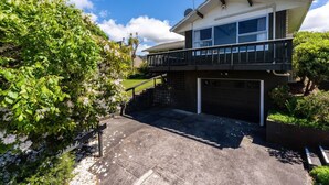 A two-story house with a balcony, a garage, and a driveway.