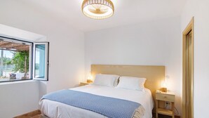 Une chambre à coucher avec un lit, des lampes de chevet, une fenêtre et un ventilateur de plafond.