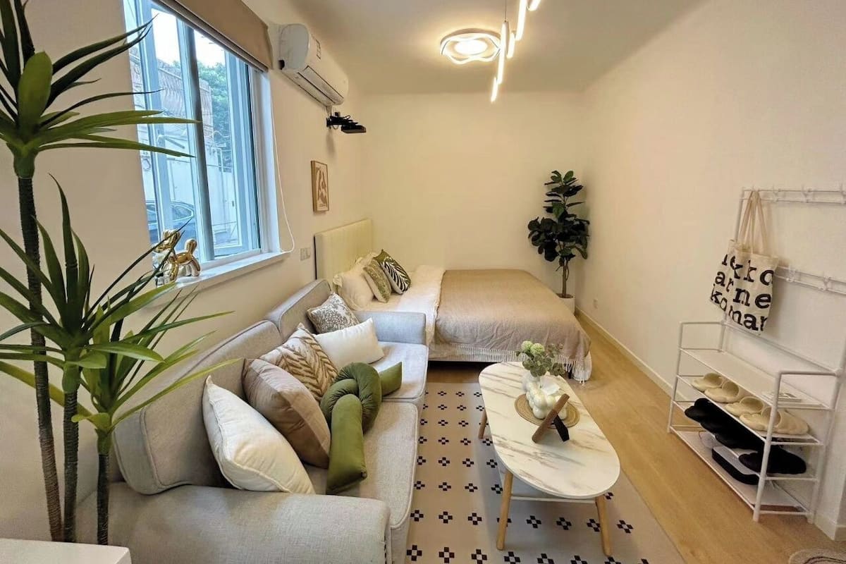 A compact living space with a sofa, a coffee table, and a shoe rack.