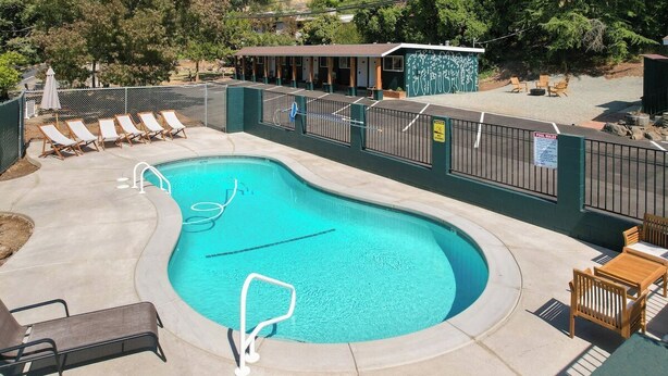 A swimming pool with lounge chairs and a covered seating area. - The General Sherman Cabin Sequoia Motel (Three Rivers)