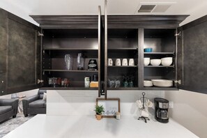 A modern kitchen with built-in cabinets, a coffee machine, and a framed sign on the counter.
