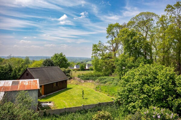 A rural property with a barn, a grassy yard, and surrounding trees.
