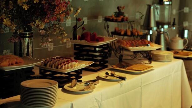 Una mesa de buffet con diferentes opciones de comida y una máquina de café.