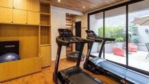 A home gym with treadmills, a Kikos exercise ball, and a wooden cabinet. - Jardim Paulista Studio Completo (Jardim Paulista São Paulo)