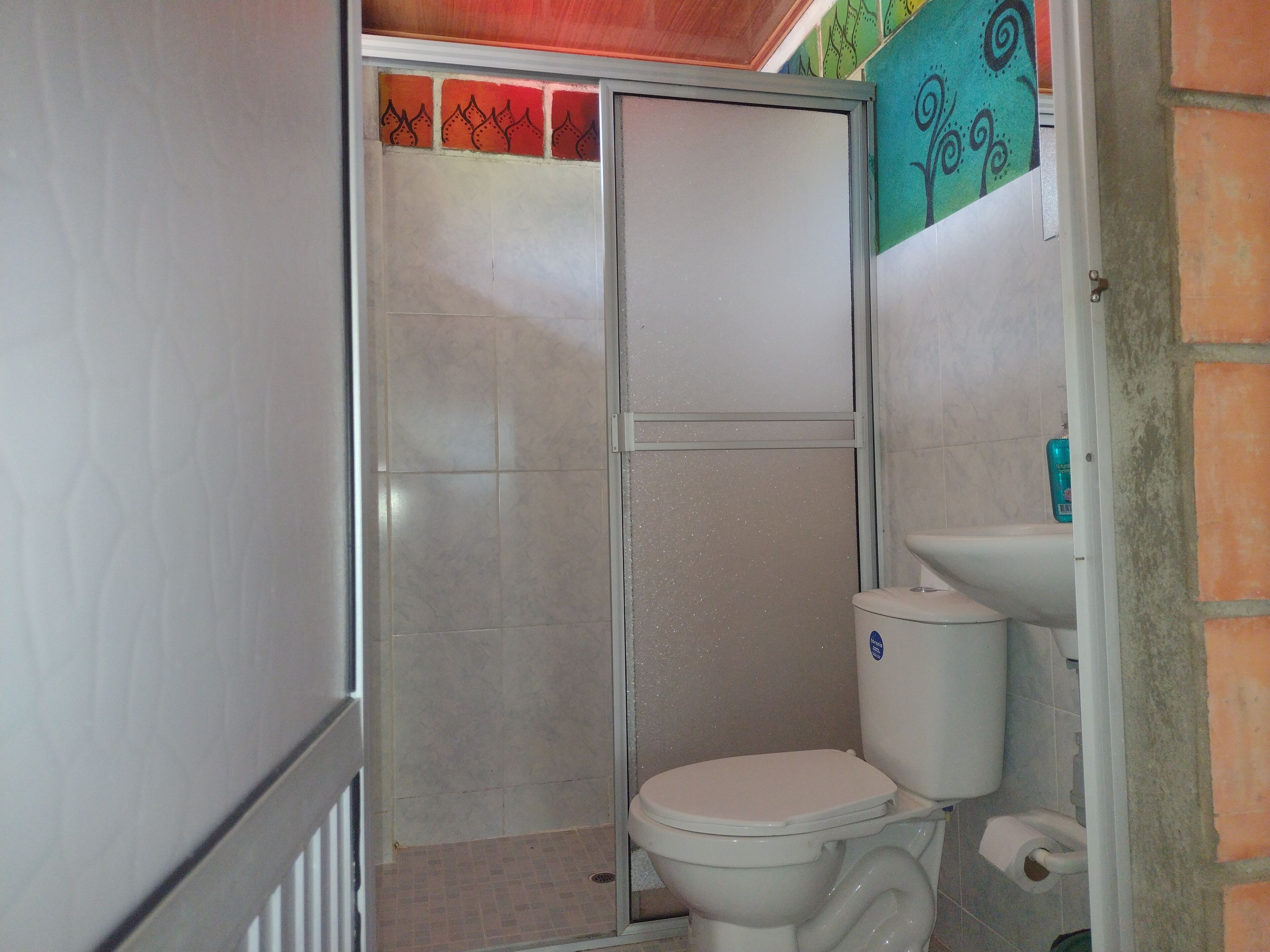 A bathroom with a shower, toilet, and sink.