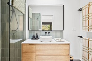 A modern bathroom with a large mirror, a round sink, and a shower enclosure. - Bella Vita (Lorne)