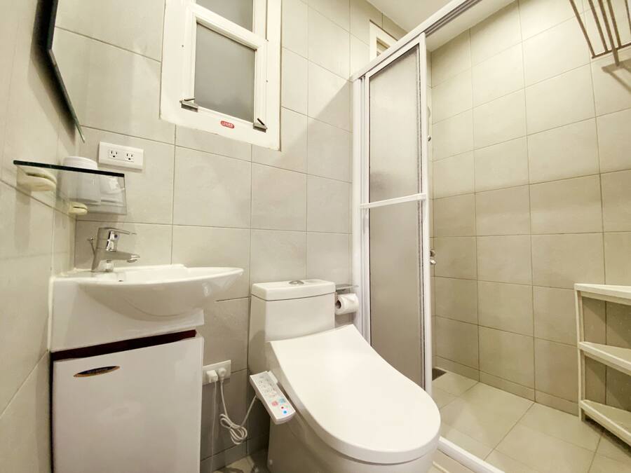 Un baño moderno con inodoro, lavamanos y ducha.