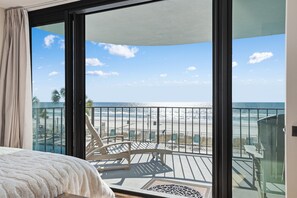 A balcony with a view of the beach and ocean.