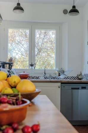 A kitchen with a window, a sink, and a dishwasher.