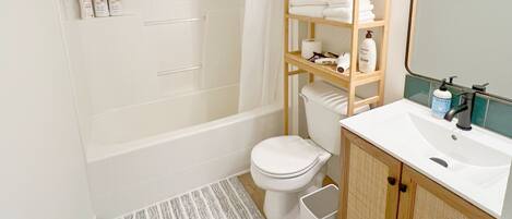 A modern bathroom with a bathtub, toilet, and sink.