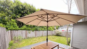 A wooden deck with a table and chairs under a large umbrella. - Family-Friendly Retreat in Marysville (Marysville)