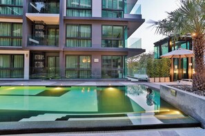 A modern hotel with a swimming pool, multiple balconies, and a well-lit outdoor area. - B305 - 1 Bedroom Condo Pool View Near Ao Nang Beach (Krabi)