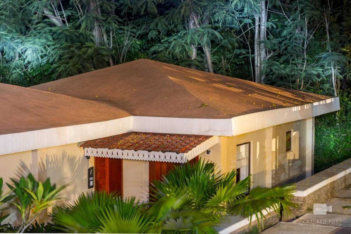 A modern building with a flat roof, surrounded by lush greenery.
