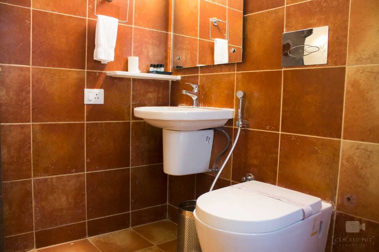 A bathroom with a white sink, a toilet, and a mirror.