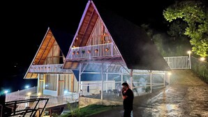 A two-story wooden house with a glass balcony, a covered outdoor area, and a paved pathway leading to a gated entrance. - La Paz Resort By Shikhar Hospitality (Nainital)