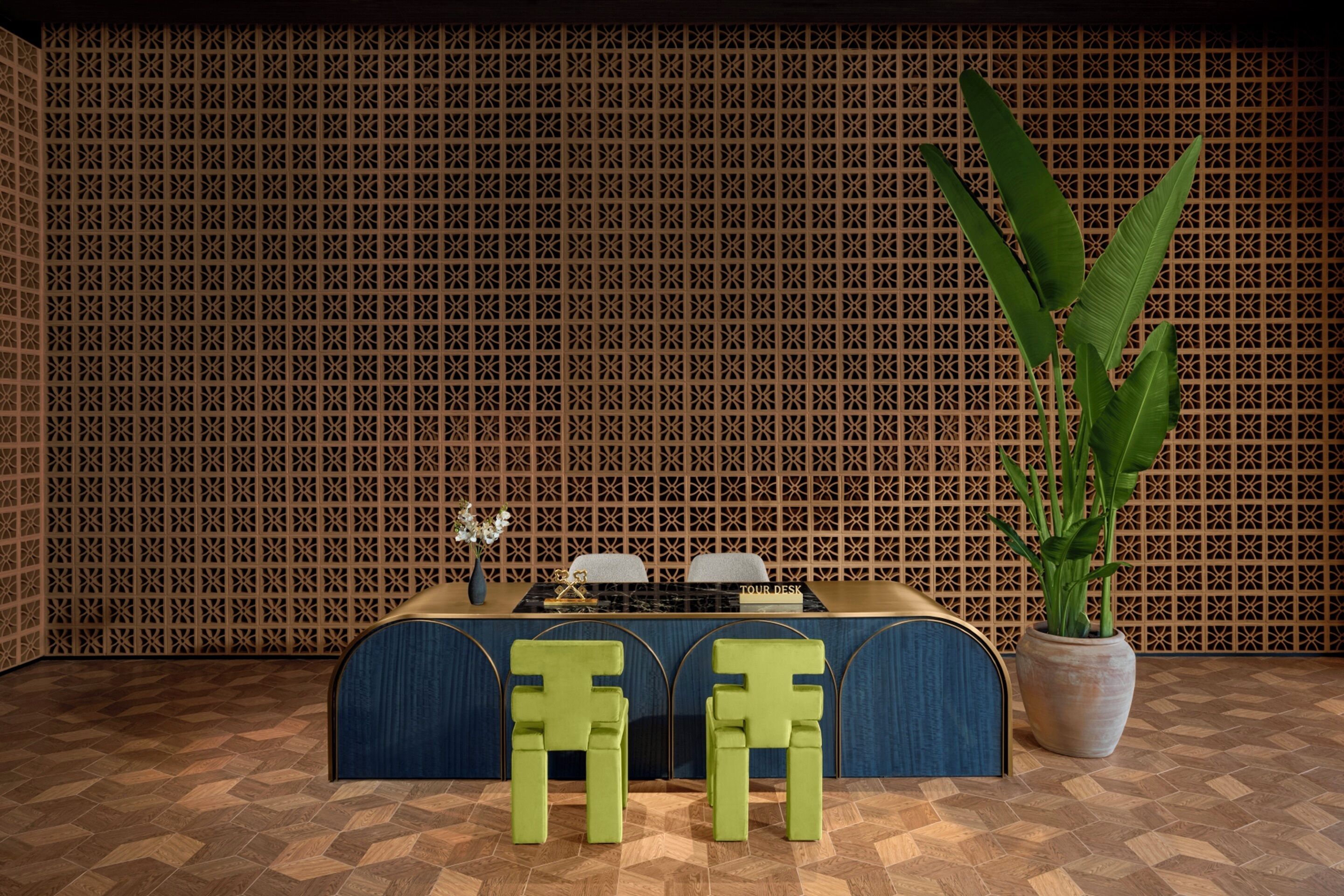 A room with a patterned wall, a table with chairs, and a potted plant.