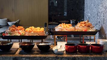 A buffet with various fried foods, bowls, and serving utensils.