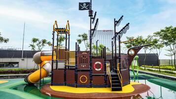 A playground with a pirate ship theme, including slides and climbing structures.