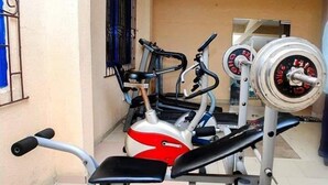 A home gym with a bench press, a rowing machine, and a weight bench. - Star Rise Golden International Hotel  (Badagry)