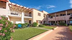 A residential building with multiple balconies, a well-maintained lawn, and a clear sky. - Residence I Mirti n. 8 (Santa Teresa di Gallura)