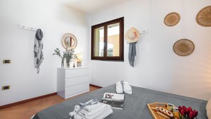 A bedroom with a bed, a dresser, a window, and wall decorations. - Residence I Mirti n. 8 (Santa Teresa di Gallura)