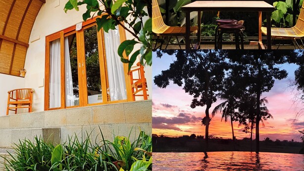 Un edificio de dos plantas con un porche cubierto, una mesa de comedor con sillas y vistas a un atardecer sobre el agua.