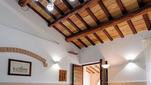 A room with exposed wooden beams, a chandelier, and a framed picture on the wall. - Villa with panoramic pool (Castorano)