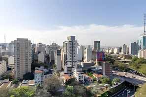 A cityscape with modern high-rise buildings, a mix of residential and commercial structures, and a clear sky. - Studio Próximo a Paulista (São Paulo)