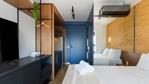 Een moderne hotelkamer met een bed, een televisie, een bureau en een kledingkast.