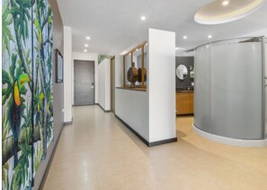 Experience the contemporary design of our hotel's inviting corridors, featuring a vibrant mural and sleek, minimalist aesthetic.