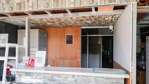 A reception desk with a stone counter, a wooden wall, and a security camera.