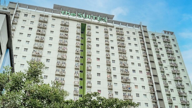 A high-rise hotel with multiple balconies and a sign reading "The Suites".
