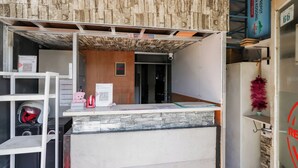 A reception area with a stone counter, a camera, and a teddy bear.