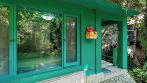 Ein grünes Gebäude mit einem großen Fenster und einer kleinen Veranda.