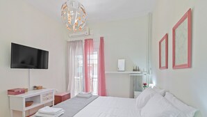 A bedroom with a bed, a TV, a desk, and a window with curtains. - Faliron Urban Retreat (Palaio Faliro)