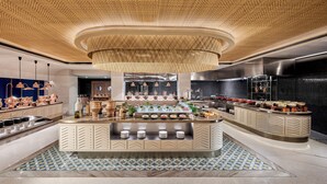 Une cuisine moderne dotée d’un îlot central, d’appareils électroménagers en acier inoxydable et d’un revêtement de sol à motifs.