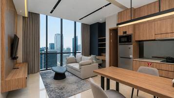 Una sala de estar moderna con vistas a la ciudad, un comedor y una kitchenette.