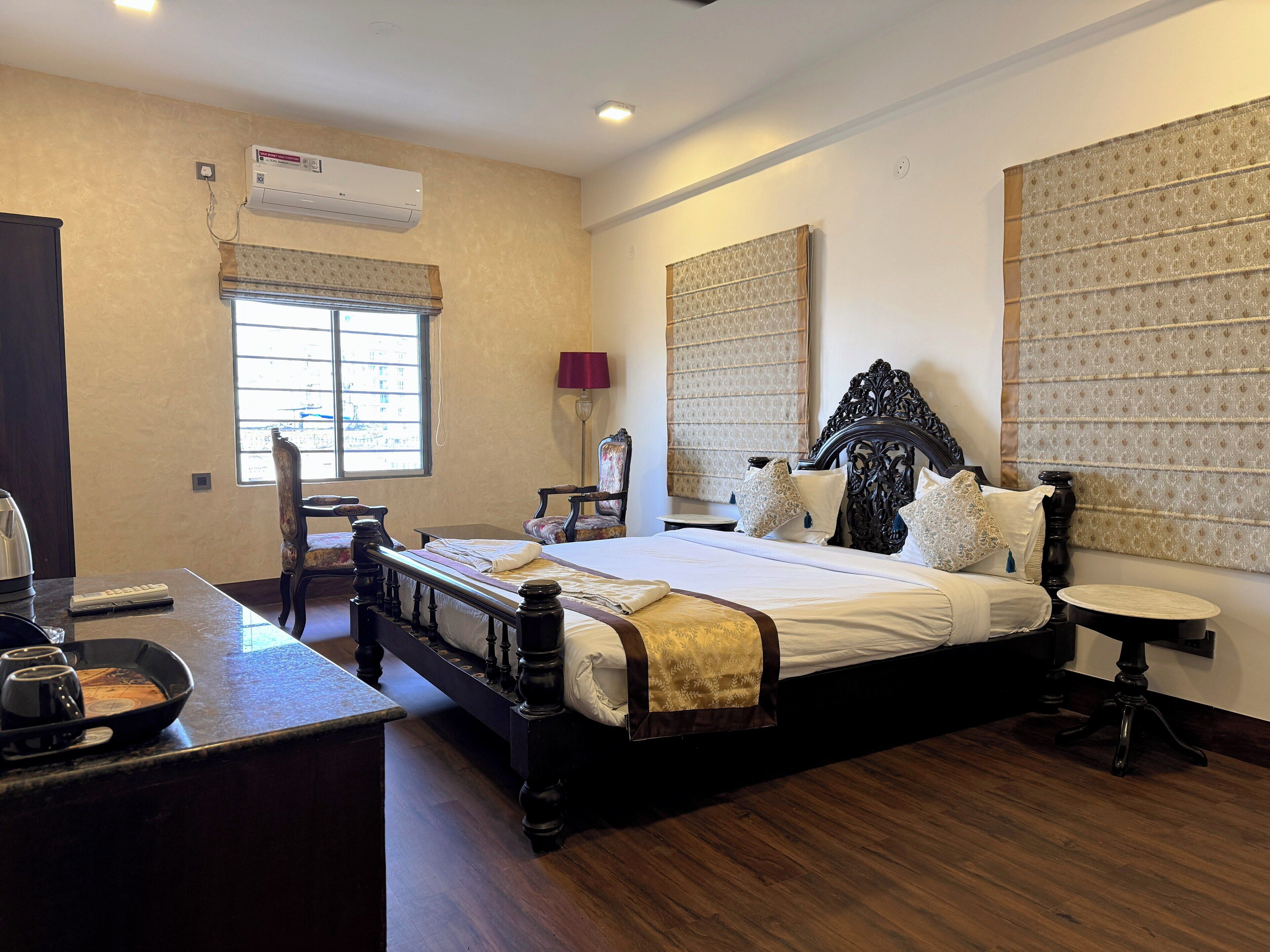 A bedroom with a large bed, a desk, and a chair.